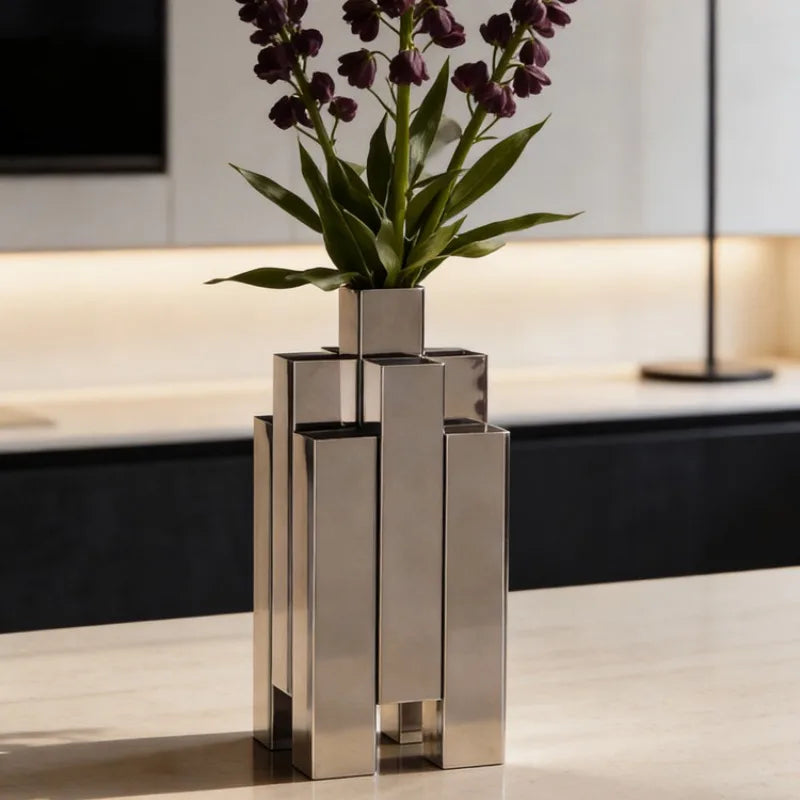 Modern metal vase with purple flowers on display, showcasing stylish design. A required field is missing.