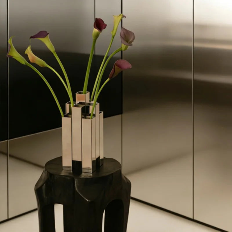 Stylish floral arrangement in a sleek vase on an artistic stool; A required field is missing.